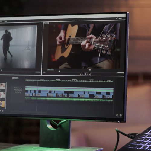 Male freelancer working on movie production with computer software, editing film montage with audio and visual effects. Creating multimedia content with footage, color grading creative app.